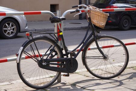 city bike with wicker basket is parked at the road, ecological mode of transport, sports lifestyle. convenient cityの写真素材