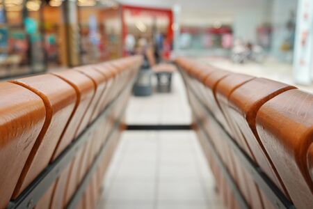 bluer, downstairs view of Mall. wooden benches for visitors. the structure of the material texture. in the distance there are people with shopping.の写真素材