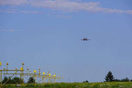 the aircraft approaches runway on a Sunny summer day against the blue sky, reducing the height and...