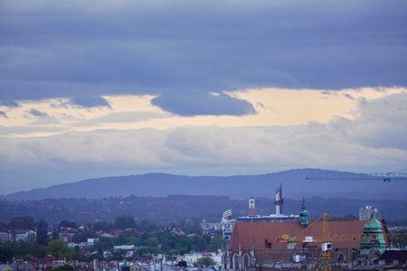 roofs of houses and Church at sunset, the dark sky with clouds before a thunderstorm. old town top...