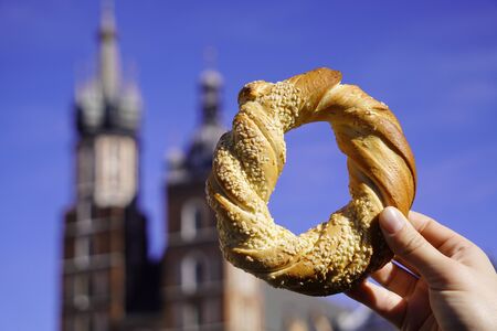 spire of the Church tower in a frame of bagel, traditional Krakow bagel. Sunny warm day with blue skyの写真素材