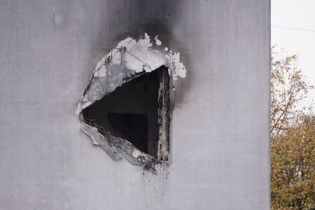 hole in concrete wall after the fire, smoke soot on the light paint, the need for repair after the fire, restorationの写真素材