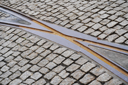 intersection of rusty rails in the old town on road of cobblestones. transport network in the city,...