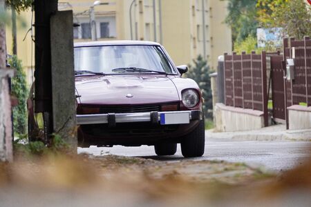 Poland, Krakow - October 4, 2019: Datsun 280Z dark cherry color, japanese oldtimer car lot in a residential area. City Parking, Parking in a closed area. Japanese car, japanese retrocar.のeditorial素材
