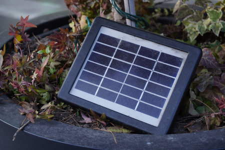 a small solar cell designed to generate low-power electricity outdoors, surrounded by vegetation,...
