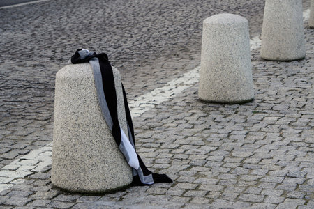 lost or forgotten things, warm striped scarf lies on the road fence waiting for the owner. lost and found, inattentive or forgetful people.の写真素材