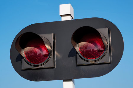 traffic light for a railway crossing, two red lights against a blue sky. forbidding sign for leaving...