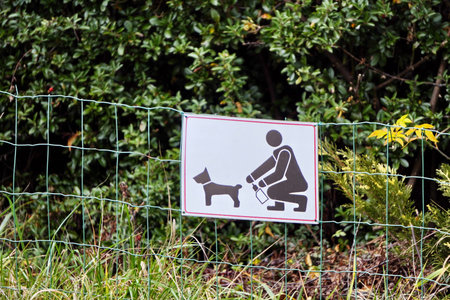 Krakow, Poland 05.01.2019: White information sign with a picture informing you about the need to clean up waste left by Pets. Sign shows the cleanliness when pets excrete in the village area.のeditorial素材