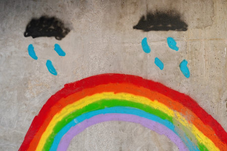 Krakow, Poland 23.01.2020: Drawing of a rainbow on a gray concrete wall, street art. Multicolored...