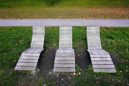 places to relax on wooden benches near modern houses. A cozy place in a private house, sunbeds or benches, rest after working days. courtyard near the housesの写真素材