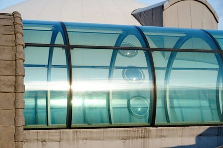 The transparent closed glass green part of tunnel of transition between buildings from outside. Modern metal and glazed passageの写真素材