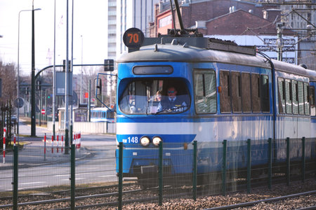 Poland, Krakow 02.22.2020: Old city blue tram on the city street. Eco-friendly urban public...