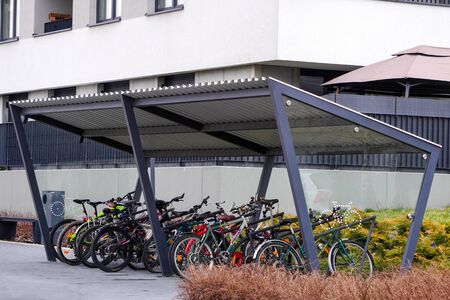 Modern Parking lot with a Bicycle roof near an apartment building with large number of bicycles. Eco-friendly and sports transport in the city.の写真素材