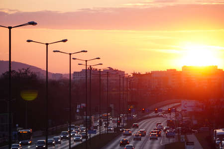 Krakow, Poland 02.18..2020: Beautiful sunset over the city. The road at sunset. Cars drive along a city street in the rays of setting sunのeditorial素材
