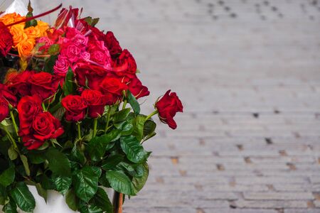 A bouquet of red roses on grey background. Selling flowers on the street. Red flowers in the waterの写真素材
