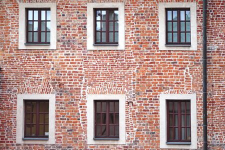 facade of an old brick building with windows or cornices. Old brick wallsの写真素材