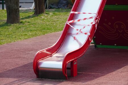 Indoor Playground for children a carousel and swings. B an o n children 's playgrounds. Prevention of coronavirus. The fight against the virus. No children on the Playground in the yard.の写真素材