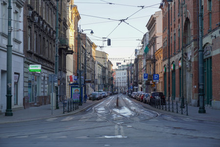 Poland, Krakow 20.04.2020: Empty, deserted streets of old city of Krakow in morning light during coronavirus pandemic. No tourists, closed restaurants and shops. Spring blue sky. Closed bordersのeditorial素材