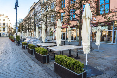 Krakow, Poland 20.04.2020: empty, deserted main market square in center of city at dawn against blue cloudless spring sky. no tourists, closed restaurants and shops. Closed state bordersのeditorial素材