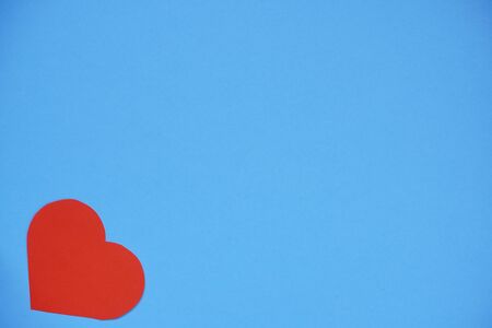 Red paper heart on a blue background, a Declaration of love. Copy space, template for designers. Valentine's day, handmade gift backgroundの写真素材