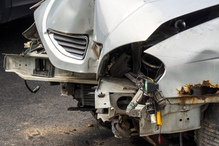 Front part of a grey passenger car damaged in an accident or traffic accident. Broken-down car, insurance payments. Disposal of damaged cars. Repair of machines.の写真素材