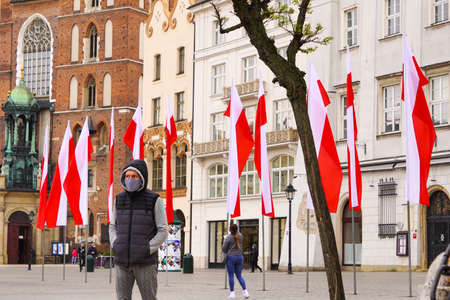 Polish red and white flags in the Old town in front of building on a Sunny day.1 of May, November 11, flag or independence or labor day. Government holiday - Poland, Krakow 03.05.2020のeditorial素材