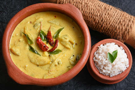 Yellow mango curry or Mampazha Pulissery sweet and sour dish for Onam Sadhya or Sadya Kerala India. organic raw ripe mango, coconut milk, seasoned with curry leaves, mustard, Indian red Kashmir chilliの写真素材