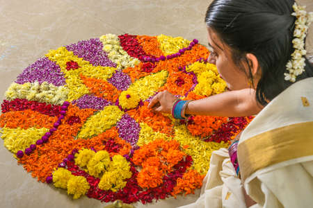 Kerala Onam festival Flower bed or Pookalam decoration, Woman putting seamless floral pattern of tropical fresh flowers on Onam, Vishu celebration of Kerala, India. 
Indian festival Diwali.の写真素材