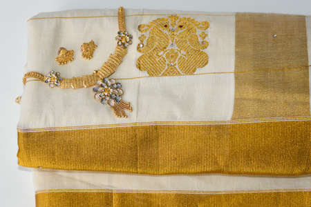 Indian silk sari, handmade white Kerala Sari and gold ornaments, jewellery. woman use this traditional wear on Onam festival, Vishu, wedding in India. multi-colored saree clothing.の写真素材