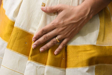 Indian silk sari, handmade white Kerala Sari and gold ornaments, jewellery. woman use this traditional wear on Onam festival, Vishu, wedding in India. multi-colored saree clothing.の写真素材