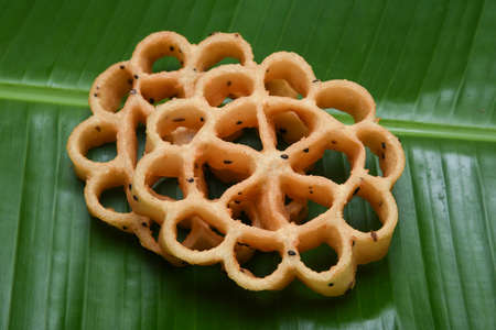 Kerala snack Achappam or rosette cookies fried snack on banana leaf popular in South India Tamil Nadu, Top view Indian tea time food fried in coconut oil.の写真素材