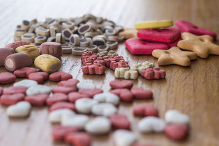 Pet food, snacks for dogs. Dog tasty colored biscuits on wooden backgroundの写真素材