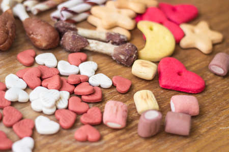 Pet food, snacks for dogs. Dog tasty colored biscuits on wooden backgroundの写真素材