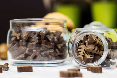 Dog treats spilling out of bowl. Dog treats and biscuitsの写真素材