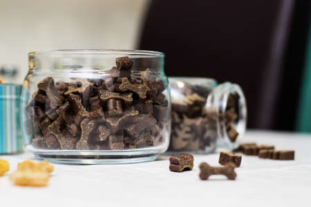 Dog treats spilling out of bowl. Dog treats and biscuitsの写真素材