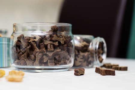 Dog treats spilling out of bowl. Dog treats and biscuitsの写真素材