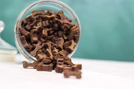 Dog treats spilling out of bowl. Dog treats and biscuitsの写真素材