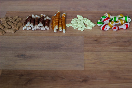Dog tasty colored biscuits on wooden background, snacks for dogs. Healthy dry pet food concept