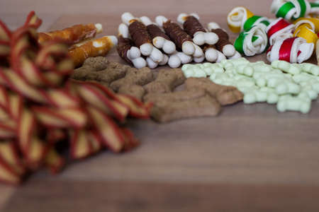 Dog tasty colored biscuits on wooden background, snacks for dogs. Healthy dry pet food conceptの写真素材