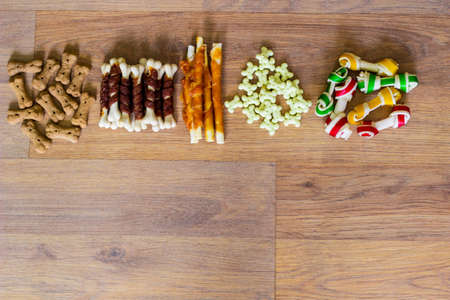 Dog tasty colored biscuits on wooden background, snacks for dogs. Healthy dry pet food conceptの写真素材