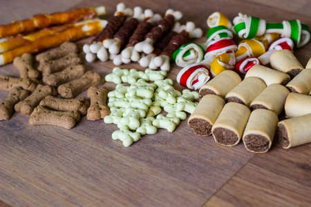 Dog tasty colored biscuits on wooden background, snacks for dogs. Healthy dry pet food conceptの写真素材
