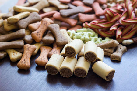 Dog tasty colored biscuits on wooden background, snacks for dogs. Healthy dry pet food conceptの写真素材