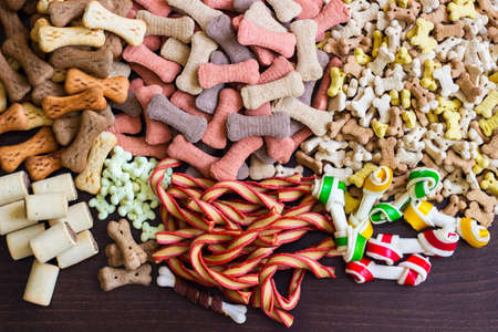 Dog tasty colored biscuits on wooden background, snacks for dogs. Healthy dry pet food conceptの写真素材