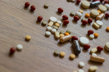 Medications and tablets on a wooden texture tableの写真素材