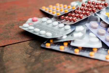 Colorful pills and capsules on wooden table, nature bokeh backgroundの写真素材