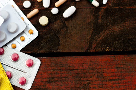Medications and tablets on a wooden texture tableの写真素材