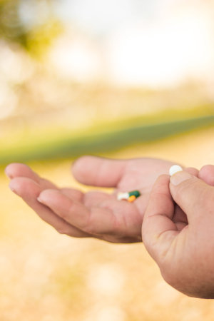 Medication in senior woman hand, bokeh background