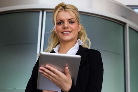 Portrait of smiling businesswoman with digital tablet pc at workplaceの写真素材