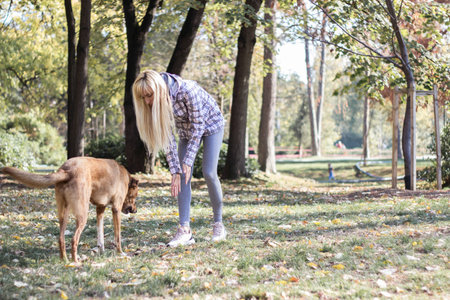 Positive young woman enjoying happy moments with her dog