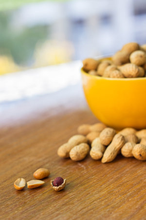 Peanuts in bowl on old wooden table
